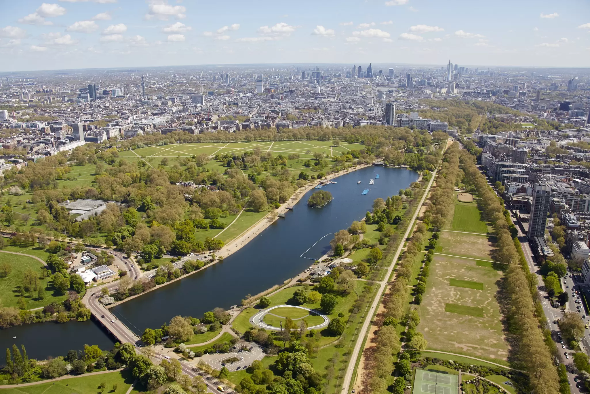 Aerial shot of a large park dominated by a central L-shaped lake