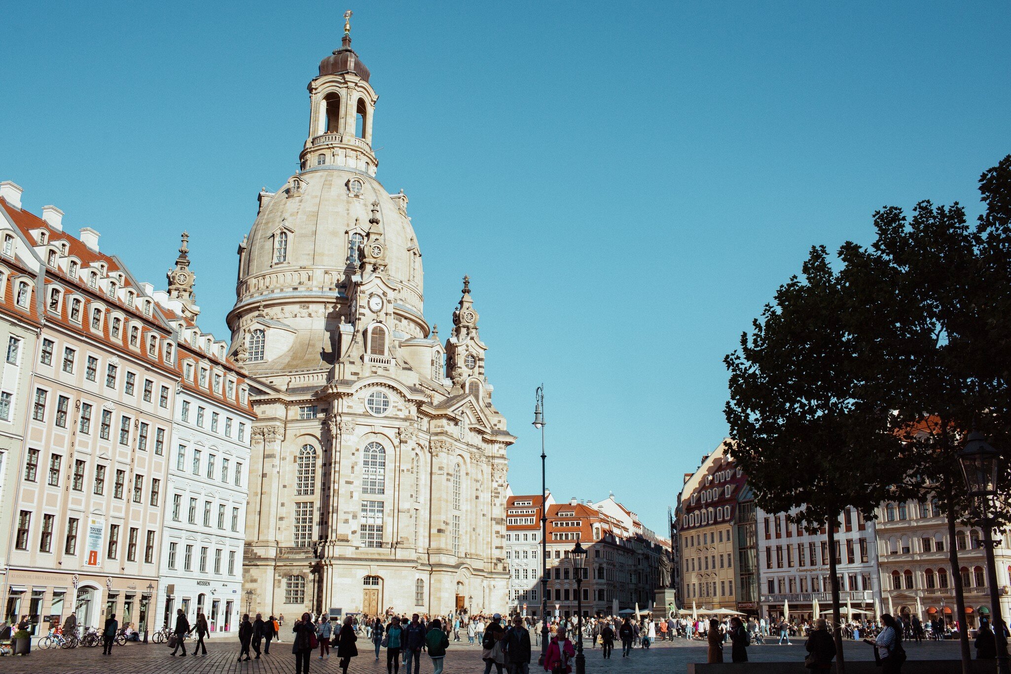 Frauenkirche in Dresden: domed sandstone baroque church above Neumarkt square, rebuilt townhouses either side, crowds below