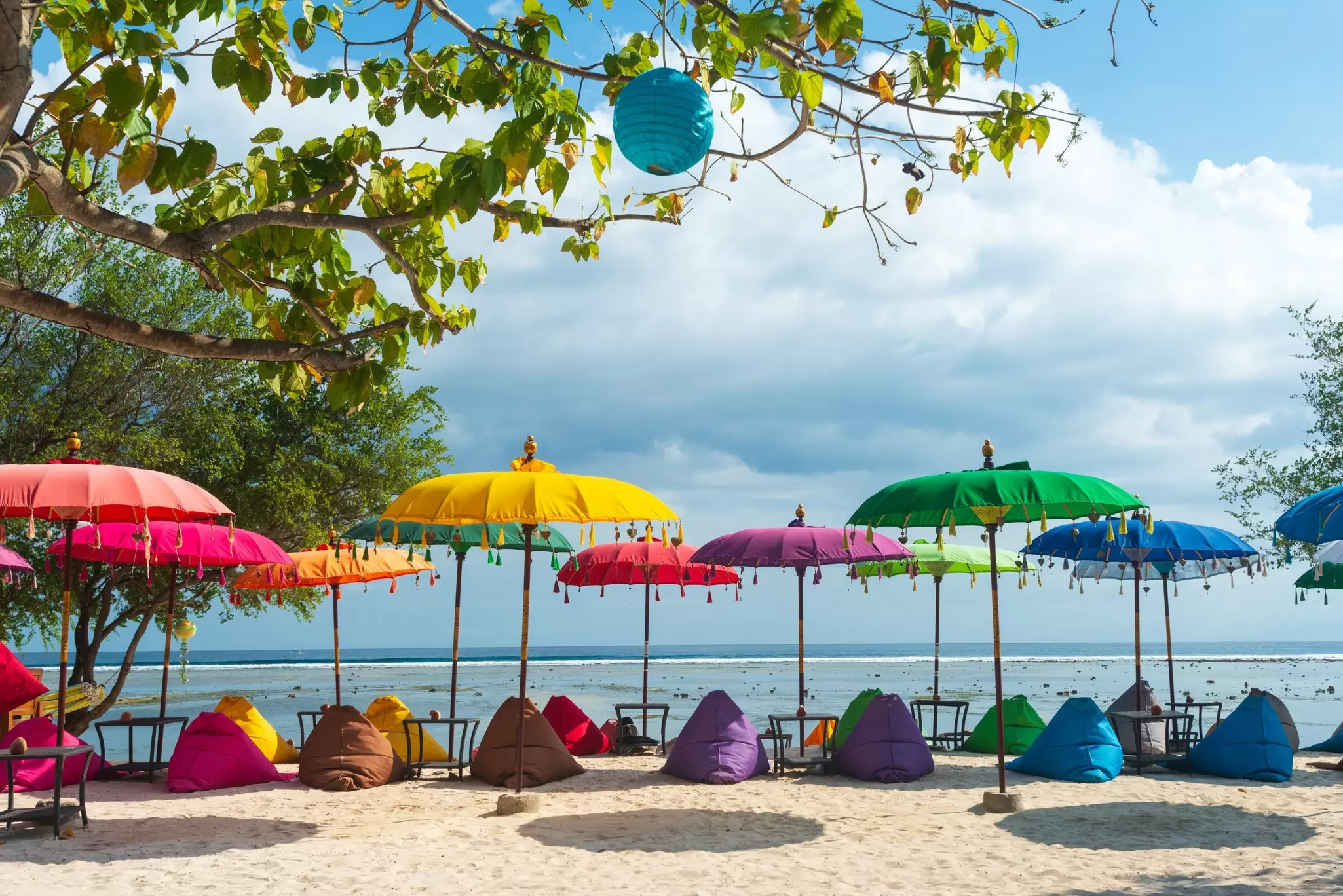 Colorful beach setup of umbrellas and lounge chairs in Gili Trawangan, Indonesia.