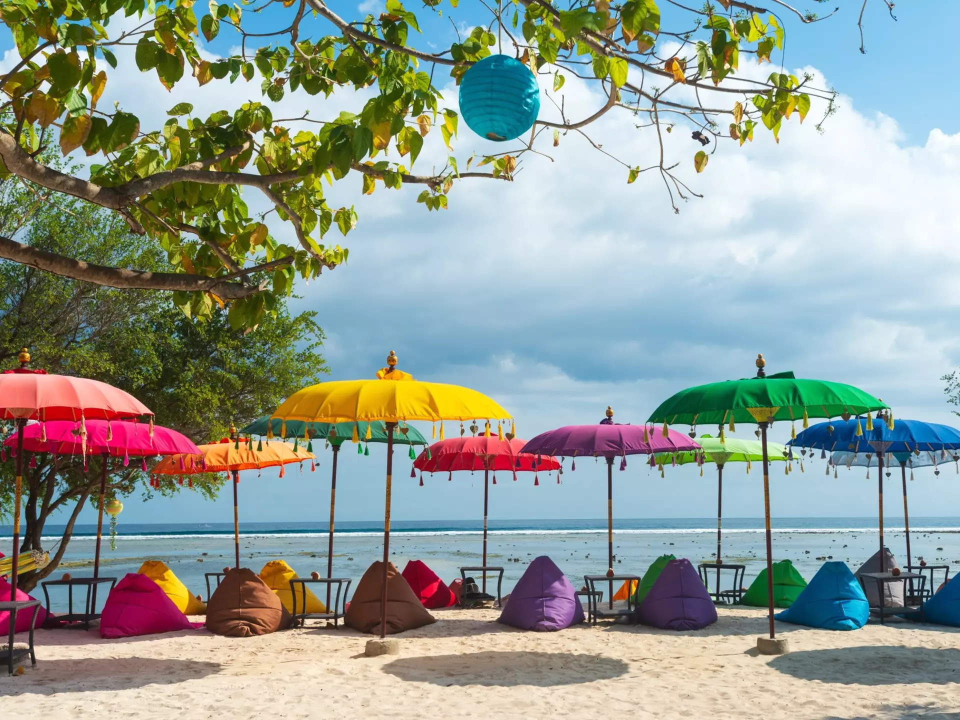 Colorful beach setup of umbrellas and lounge chairs in Gili Trawangan, Indonesia.
