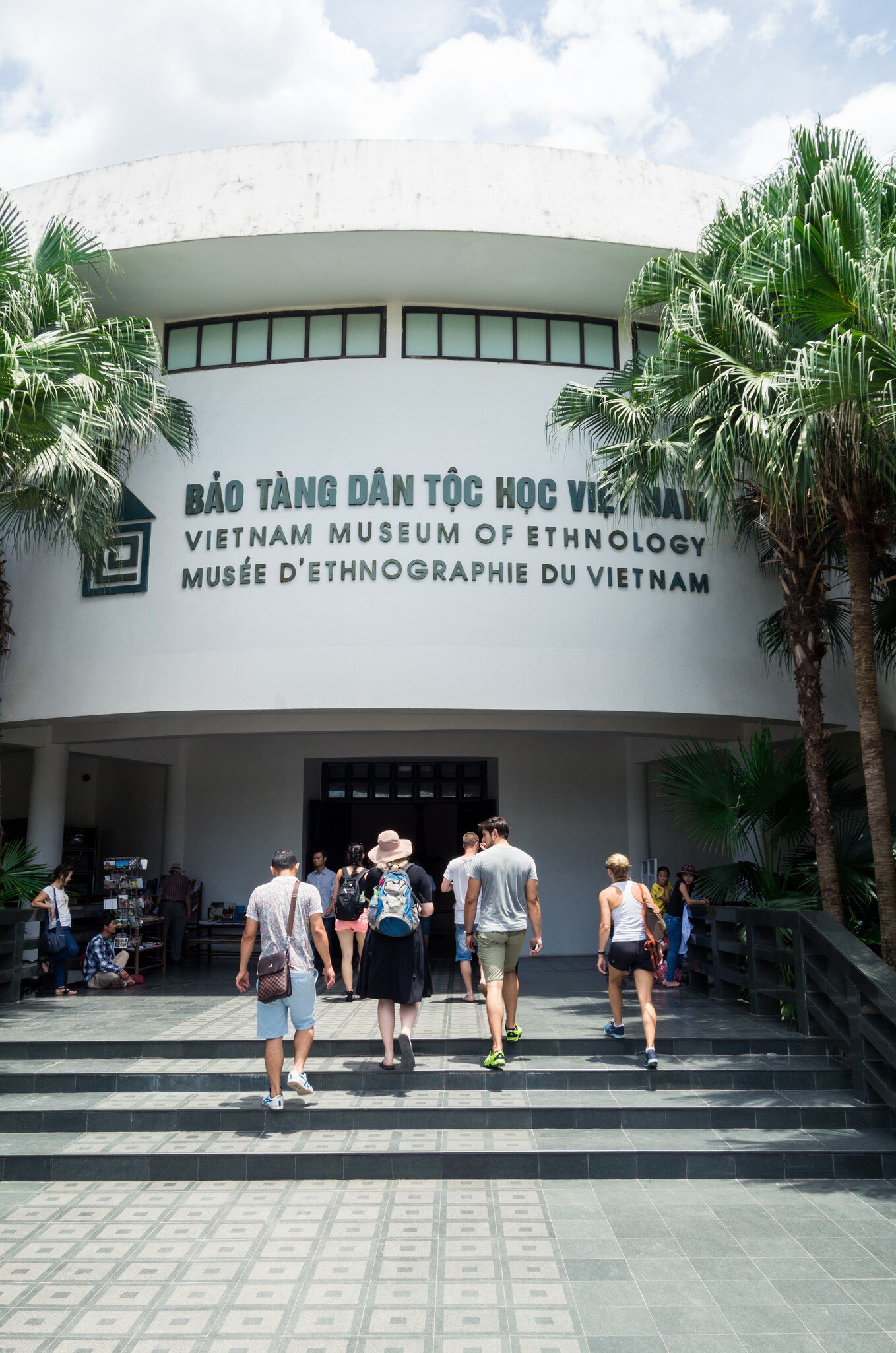 A group of tourists walks up the steps and towards the front entrance of the Vietnam Museum of Ethnology, which showcases the 54 ethnic groups of Vietnam, located in Hanoi.