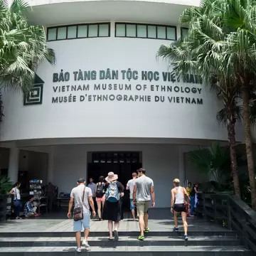 A group of tourists walks up the steps and towards the front entrance of the Vietnam Museum of Ethnology, which showcases the 54 ethnic groups of Vietnam, located in Hanoi.