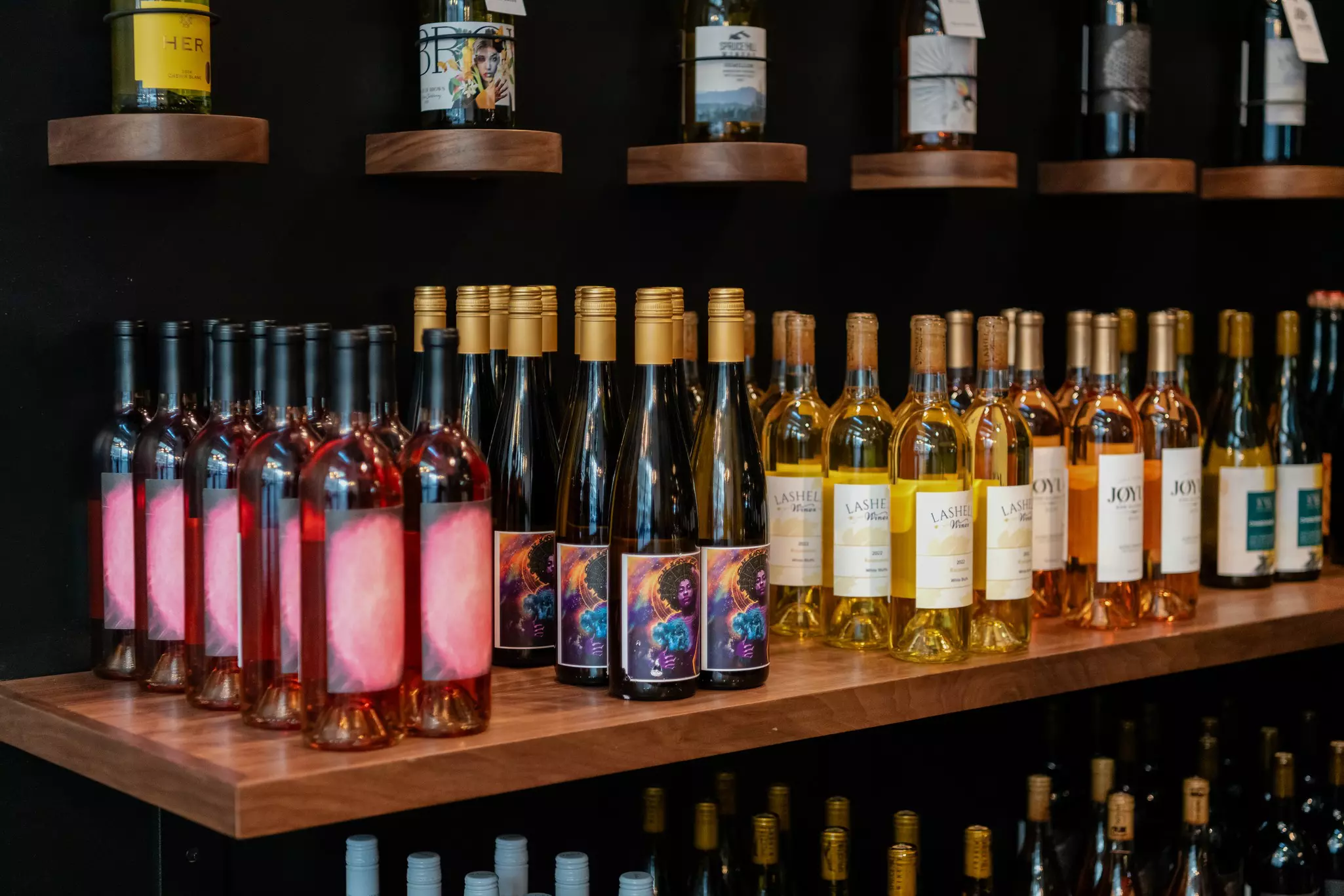 Variety of wine bottles organized on floating shelves