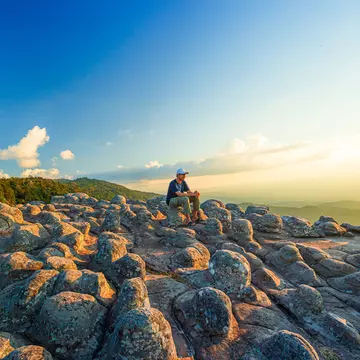 Lan Hin Pum National Park,Male tourist and mountain view,Young man with backpack sitting on rock looking into the landscape. Listening to the silence. Beautiful moment the miracle of nature.