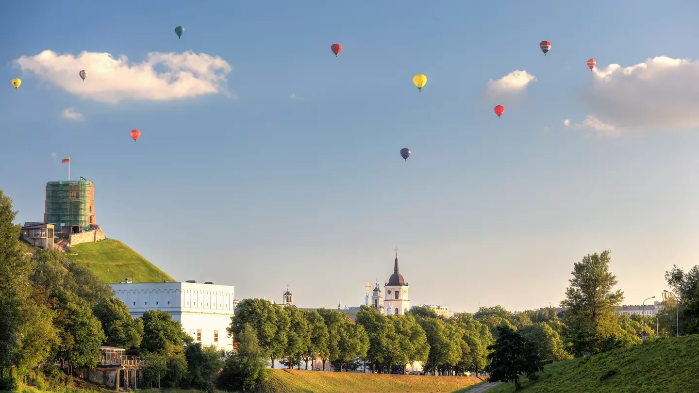 Bunch of hot air balloons in the air, giving a unique view of the city.