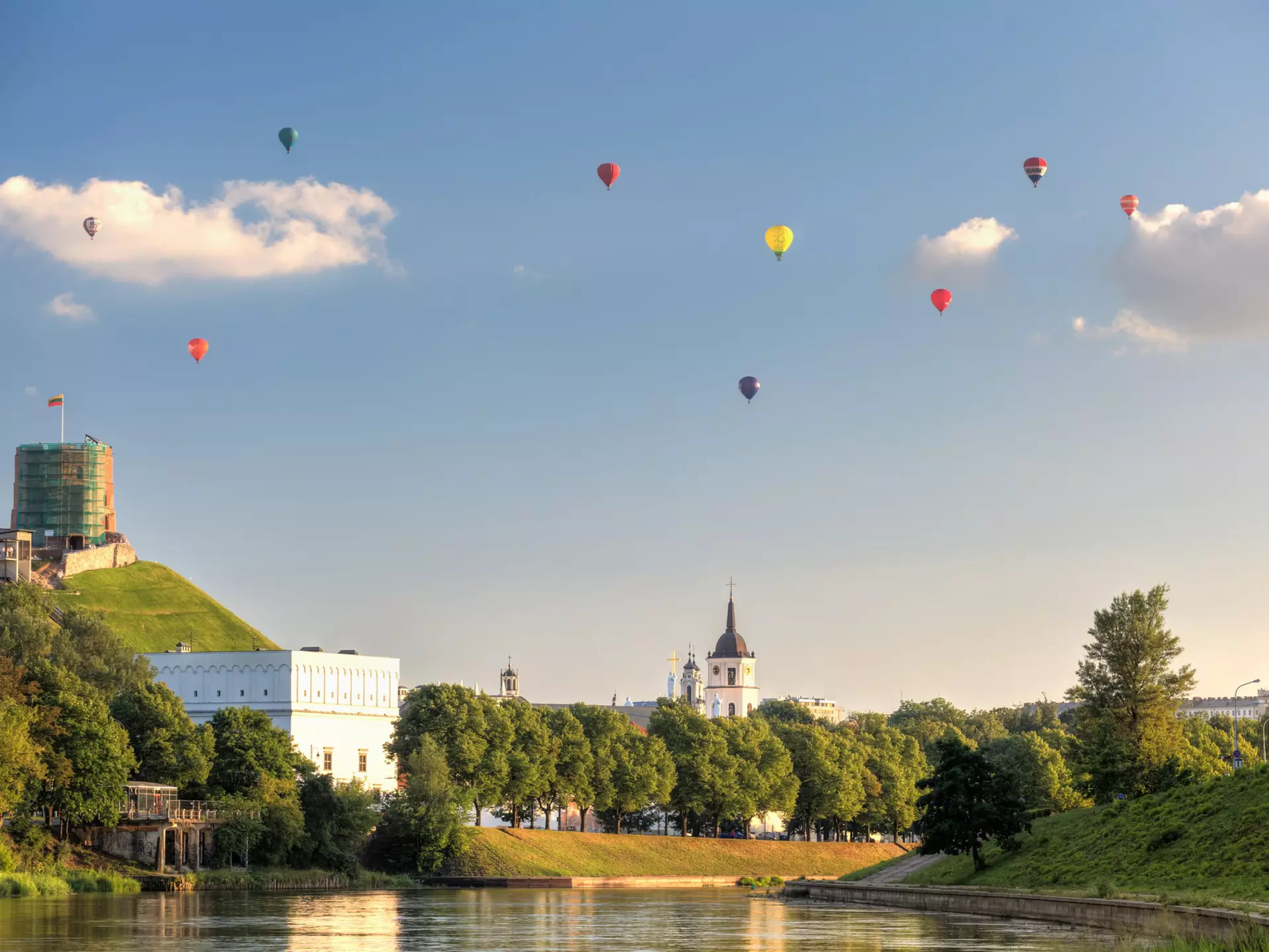 Bunch of hot air balloons in the air, giving a unique view of the city.