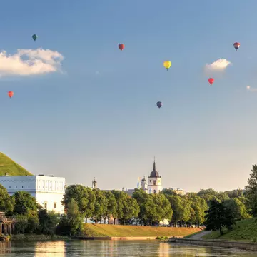 Bunch of hot air balloons in the air, giving a unique view of the city.
