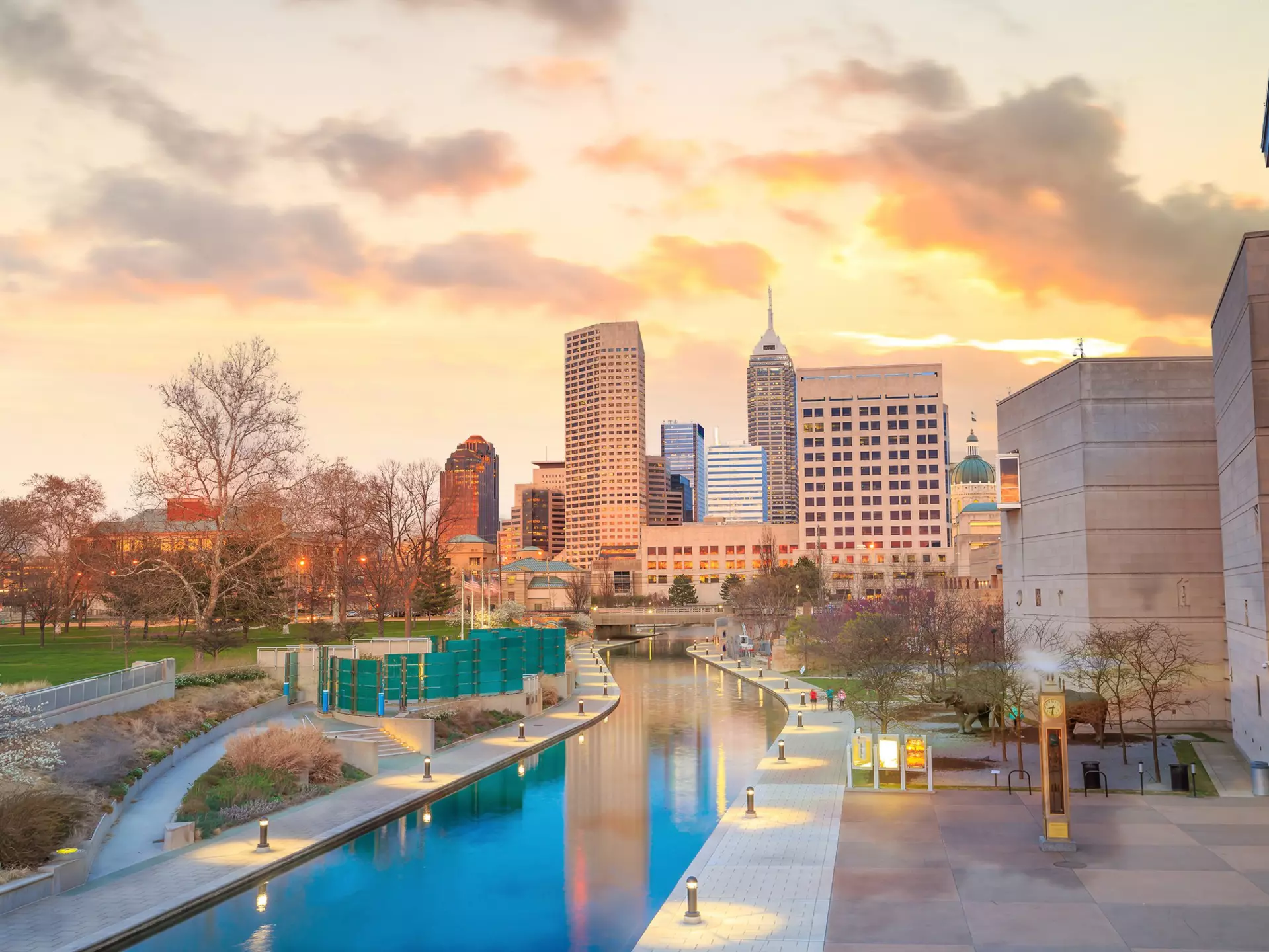 A city skyline at twilight, with a canal leading up to it