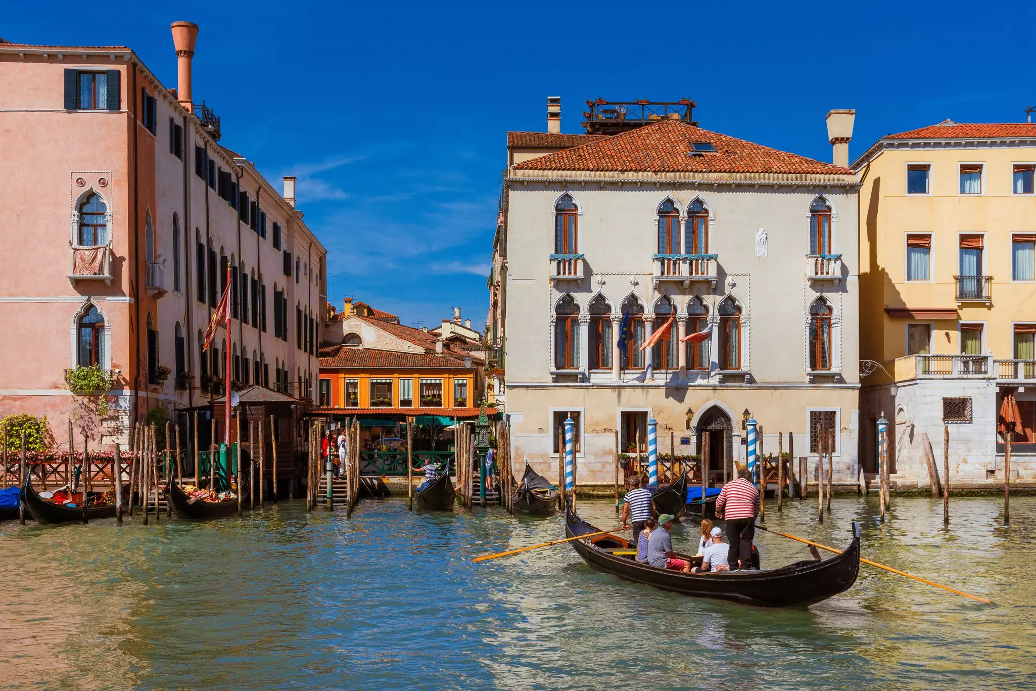 Tourists cross a canal on a gondola in the Rialto Market district, Venice