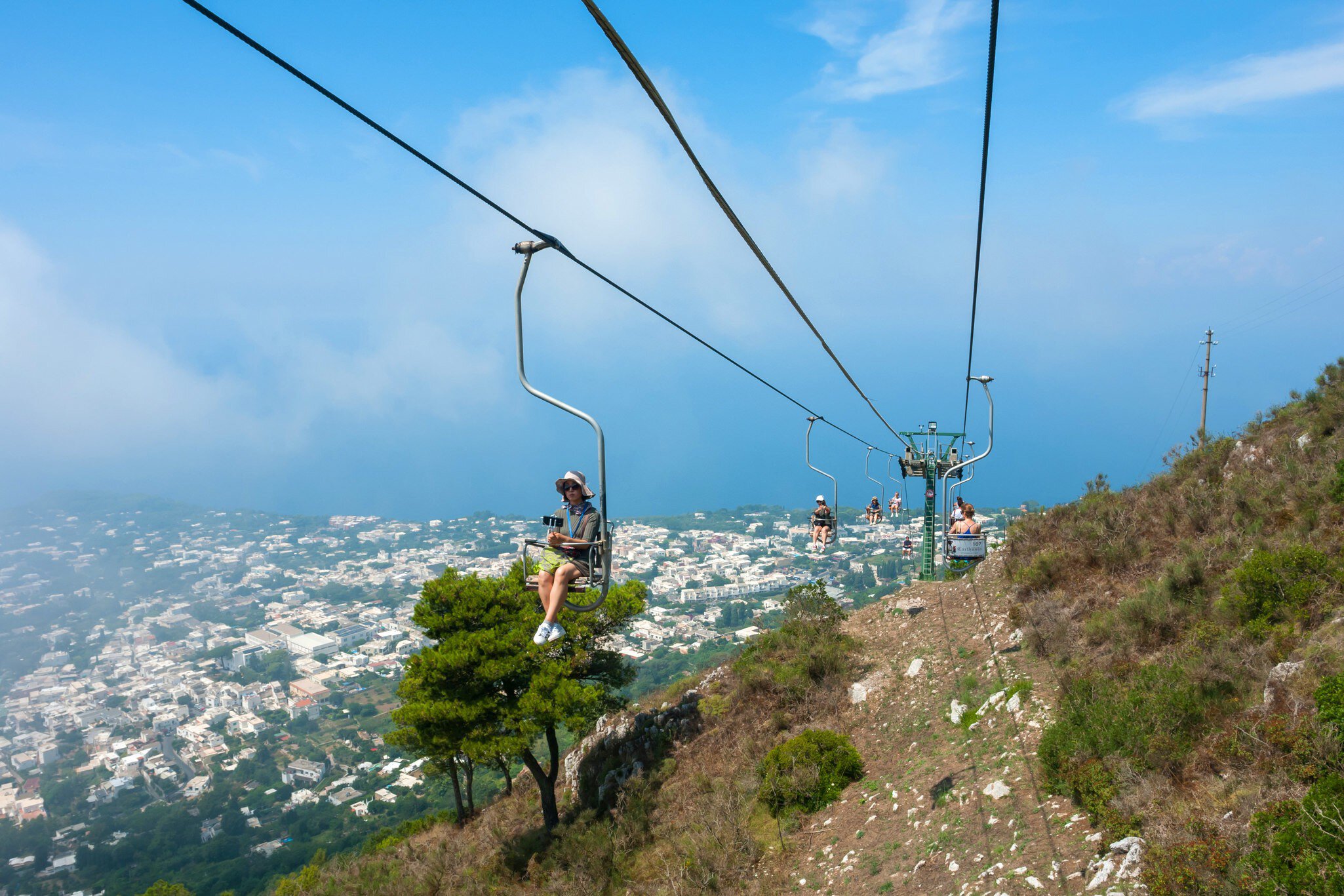 July 29, 2018: People riding up the mountain chair lift in Capri.