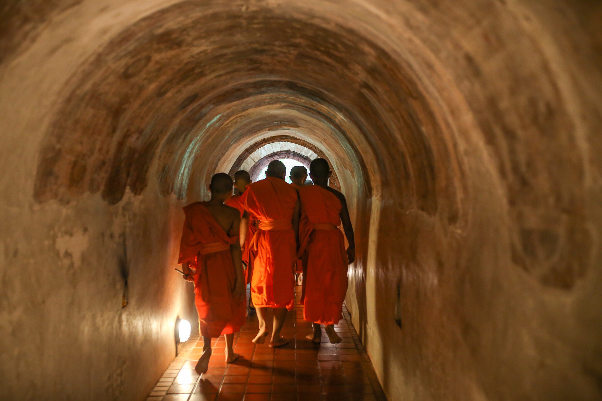 A group of monks walking inside tunnel Wat Umong or "Tunnel temple" . Wat Umong Suan Phutthatham. Chiang Mai, Thailand.