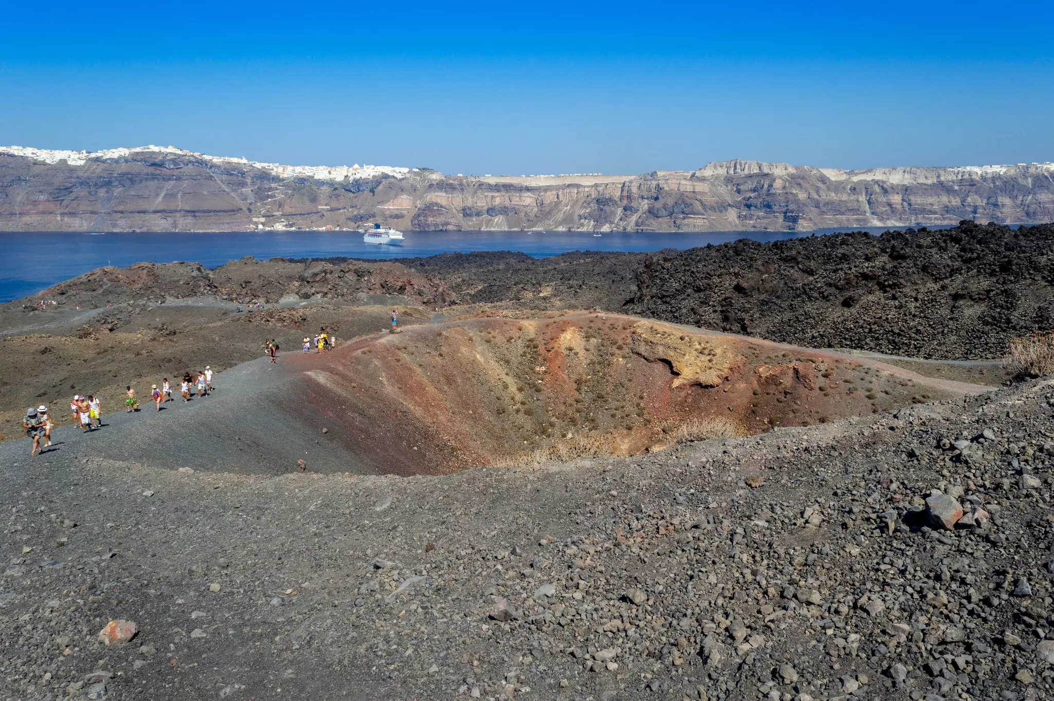 People walking along the edge of a volcanic crater
