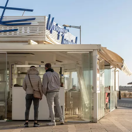 General view of a seafood restaurant in Playa de Palma de Mallorca at sunset, with customers on the premises. Island of Mallorca, Spain