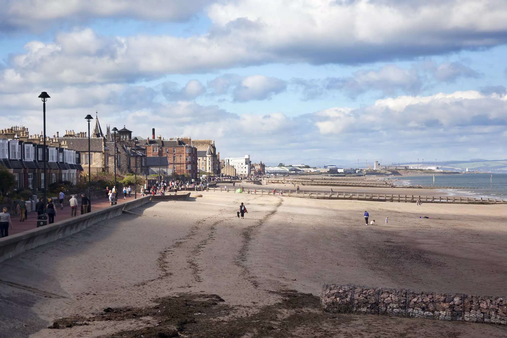 People strolling the sands and walkways of a beach