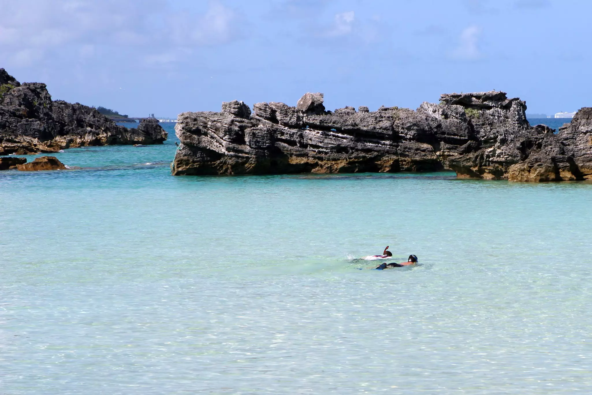 Two snorkelers in a clear cove.