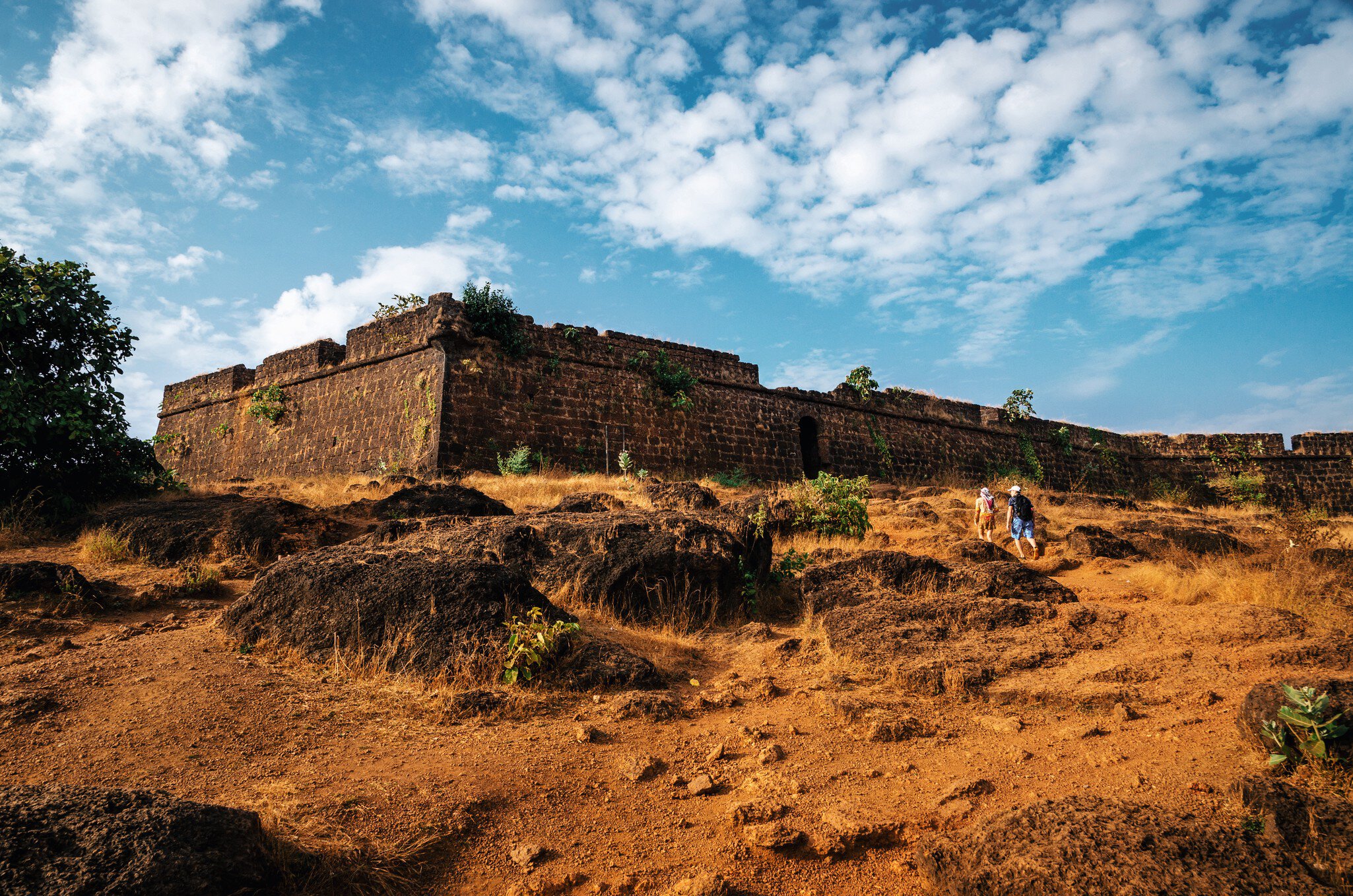 Tourists walk to the ruins of Chapora Fort, located near Vagator village, North Goa, India.