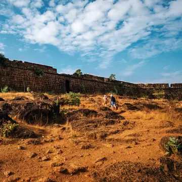 Tourists walk to the ruins of Chapora Fort, located near Vagator village, North Goa, India.