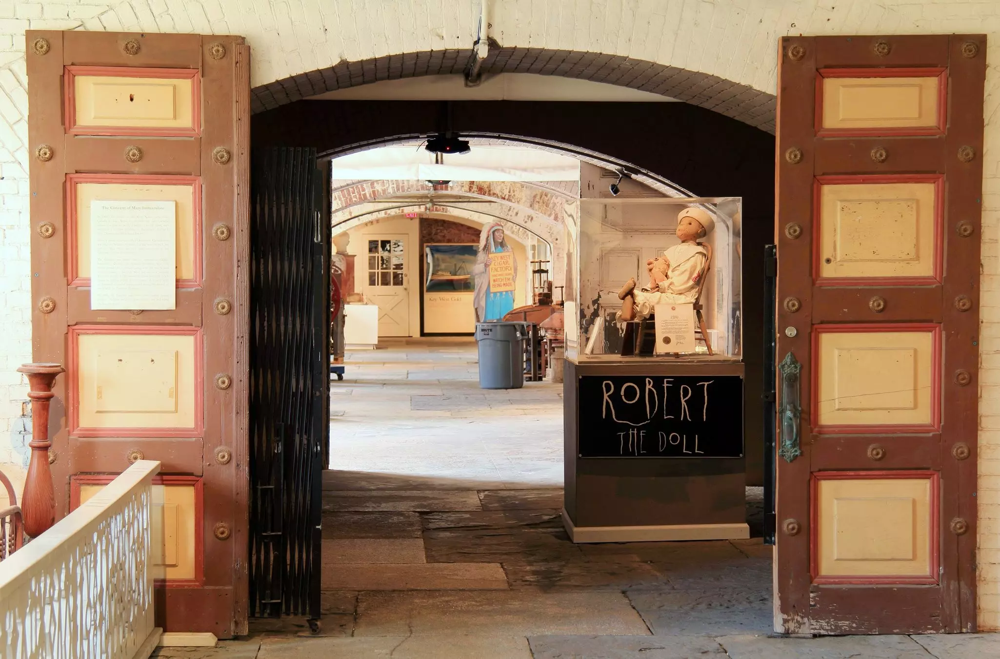 An antique doll is displayed in a case in an old fort turned into a museum.