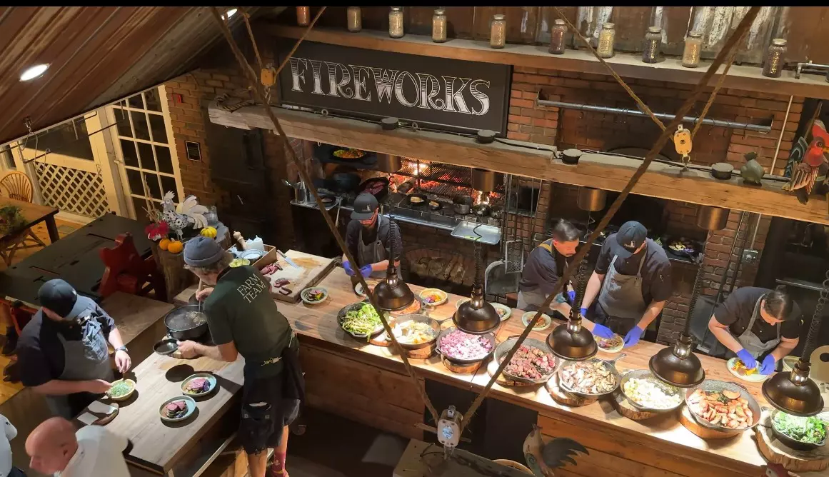 An overhead view of chefs preparing dishes in a busy kitchen.