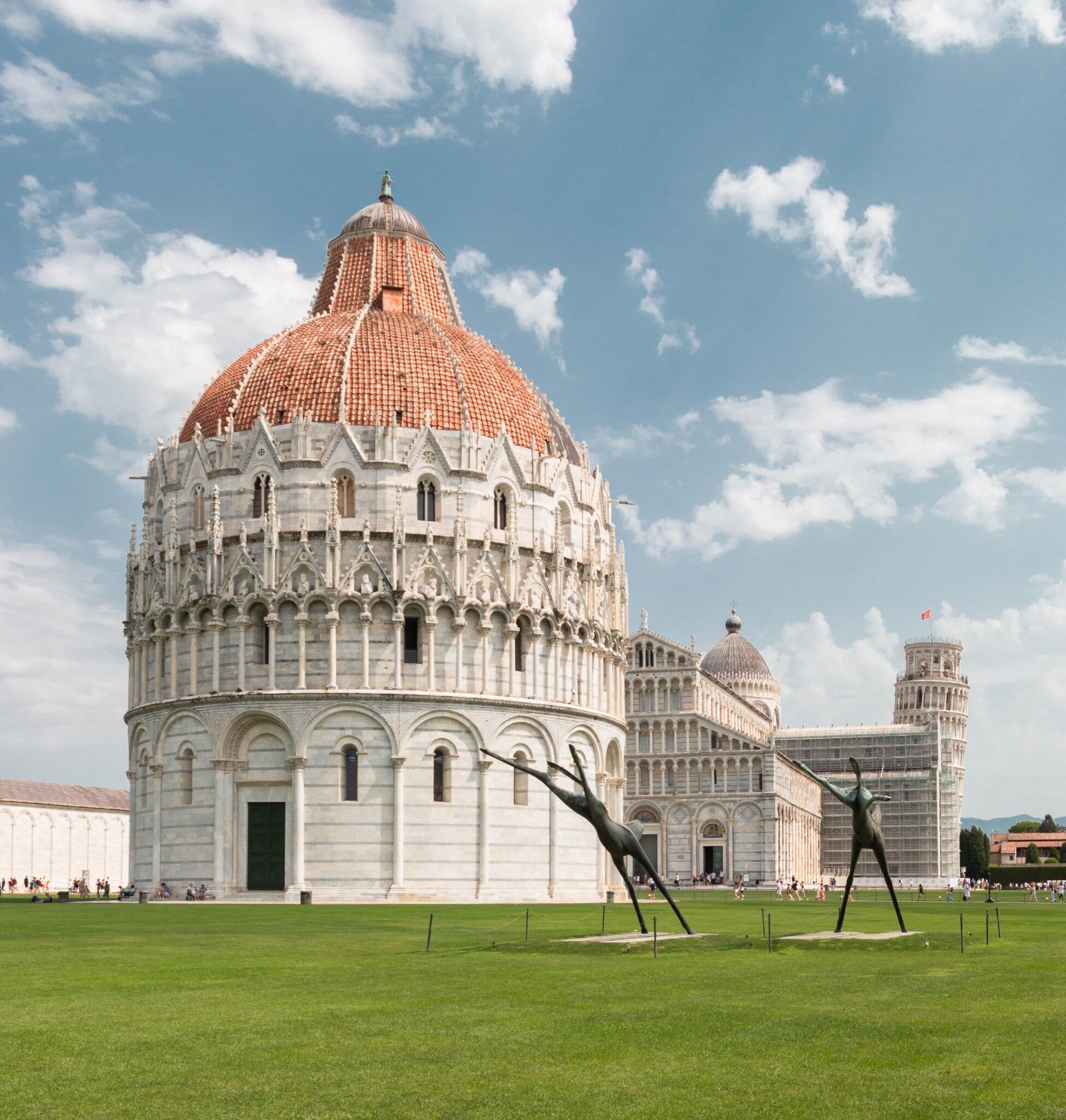 Piazza dei Miracoli in Pisa, Italy, featuring the Baptistery, Pisa Cathedral and Leaning Tower of Pisa under a clear sky.