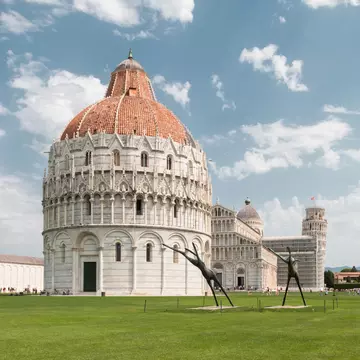 Piazza dei Miracoli in Pisa, Italy, featuring the Baptistery, Pisa Cathedral and Leaning Tower of Pisa under a clear sky.