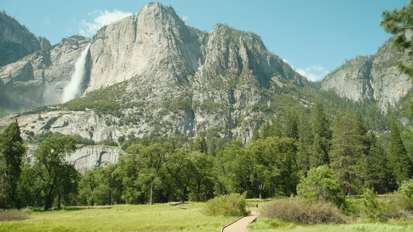 Yosemite National Park in California’s Sierra Nevada mountains green foliage on sunny day with waterfall,