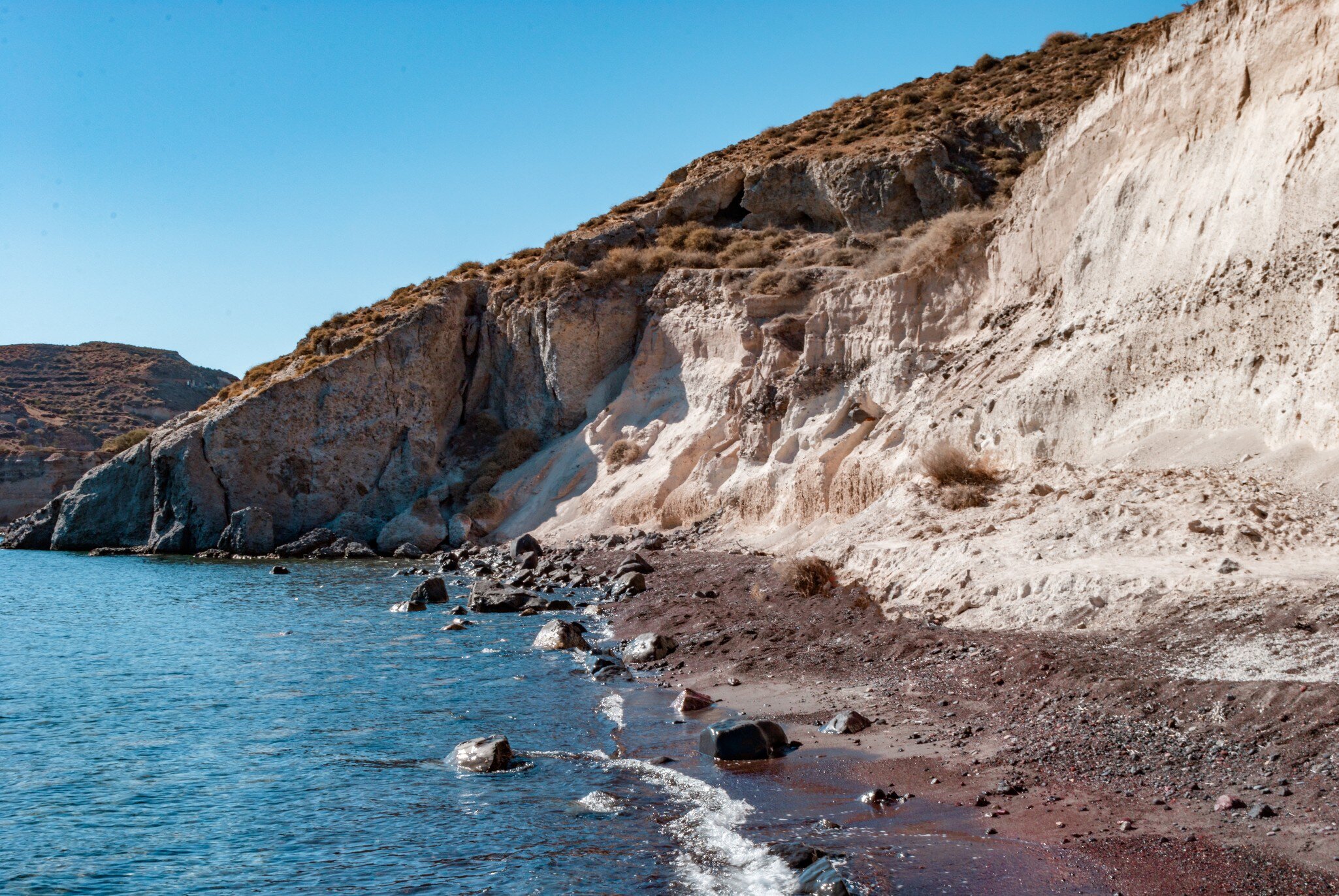 View of the water at the White (Aspri) Beach on the island of Santorini in Greece.
