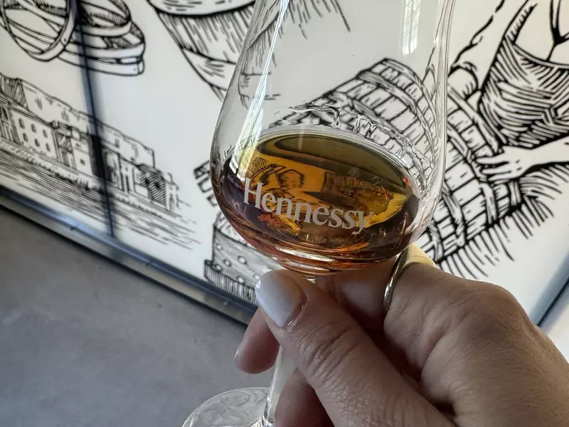 Hand holding glass of cognac at Hennessy, Cognac, France