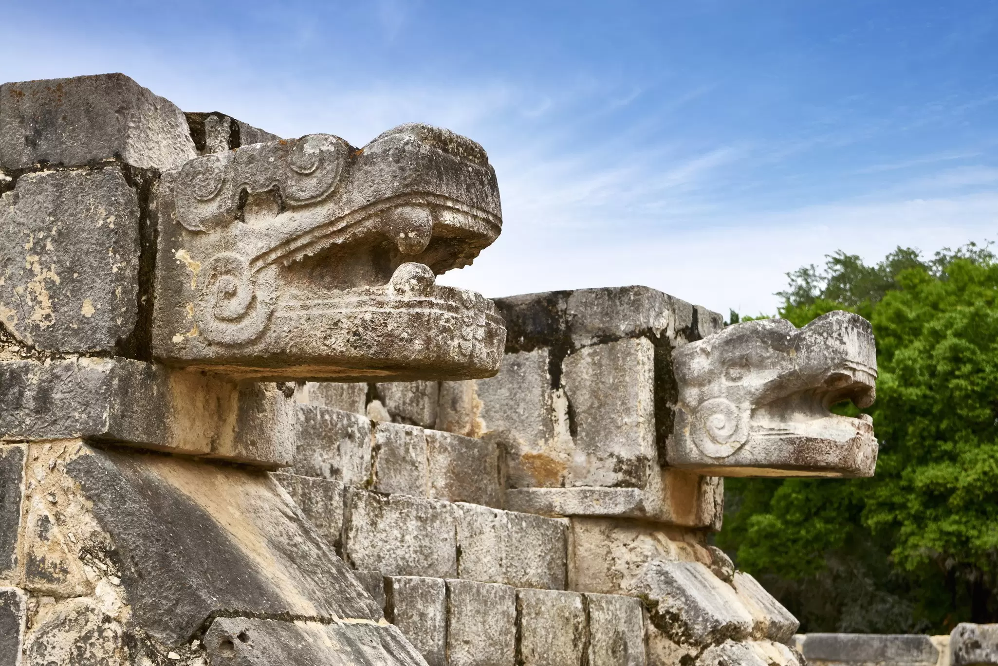Close-up of stone carvings of jaguar heads on the Plataforma de las Águilas y los Jaguares (Platform of the Eagles and Jaguars) at the Chichén Itzá complex in Mexico.