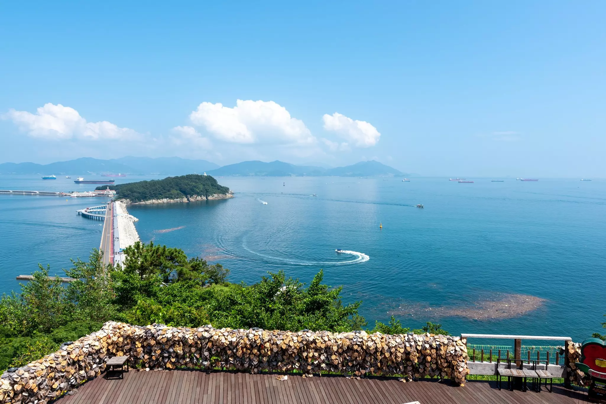 A bridge leads through the blue sea to the distant island of Odongdo, South Korea