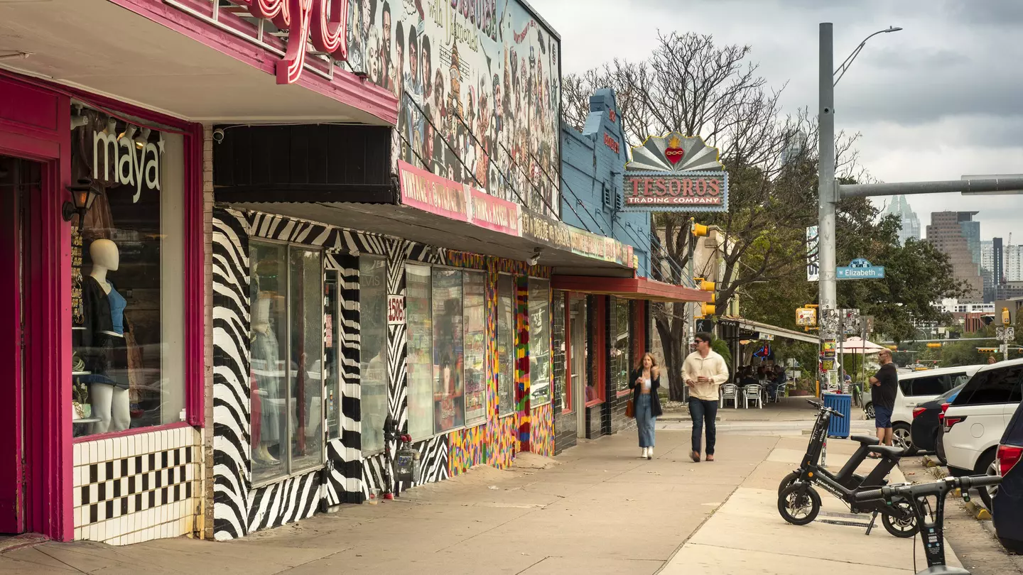 People walk along the trendy South Congress Avenue by colorful shops and restaurants in Austin, Texas.