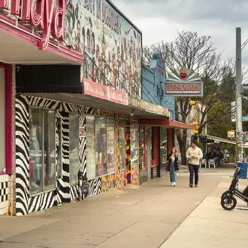 People walk along the trendy South Congress Avenue by colorful shops and restaurants in Austin, Texas.