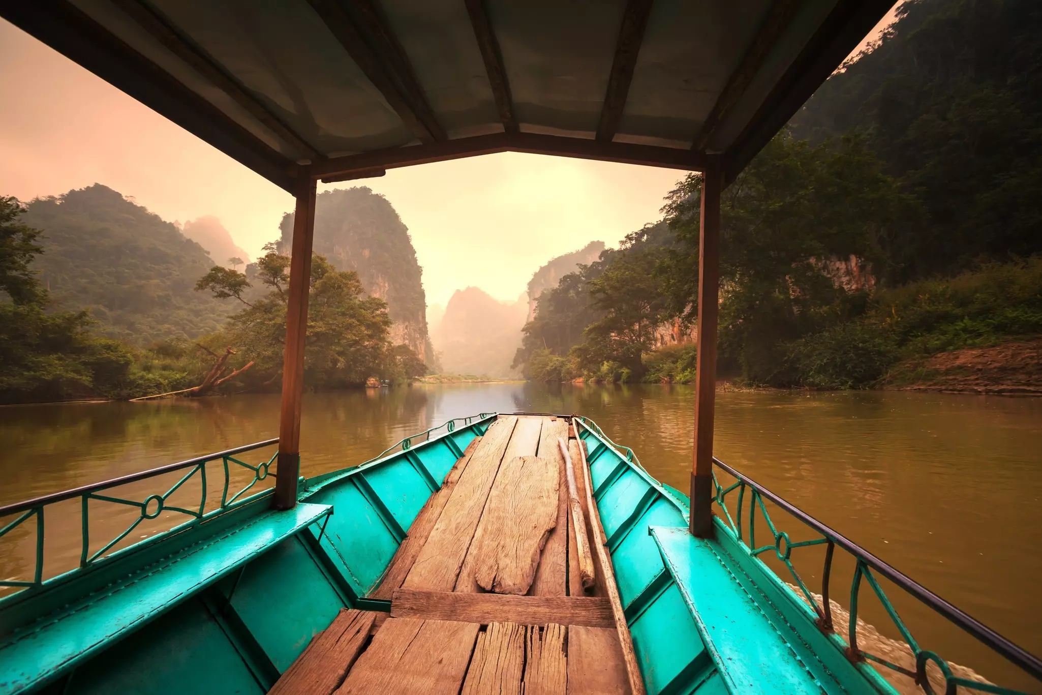 An empty boat traveling down a smooth waterway in Ba Be National Park.
