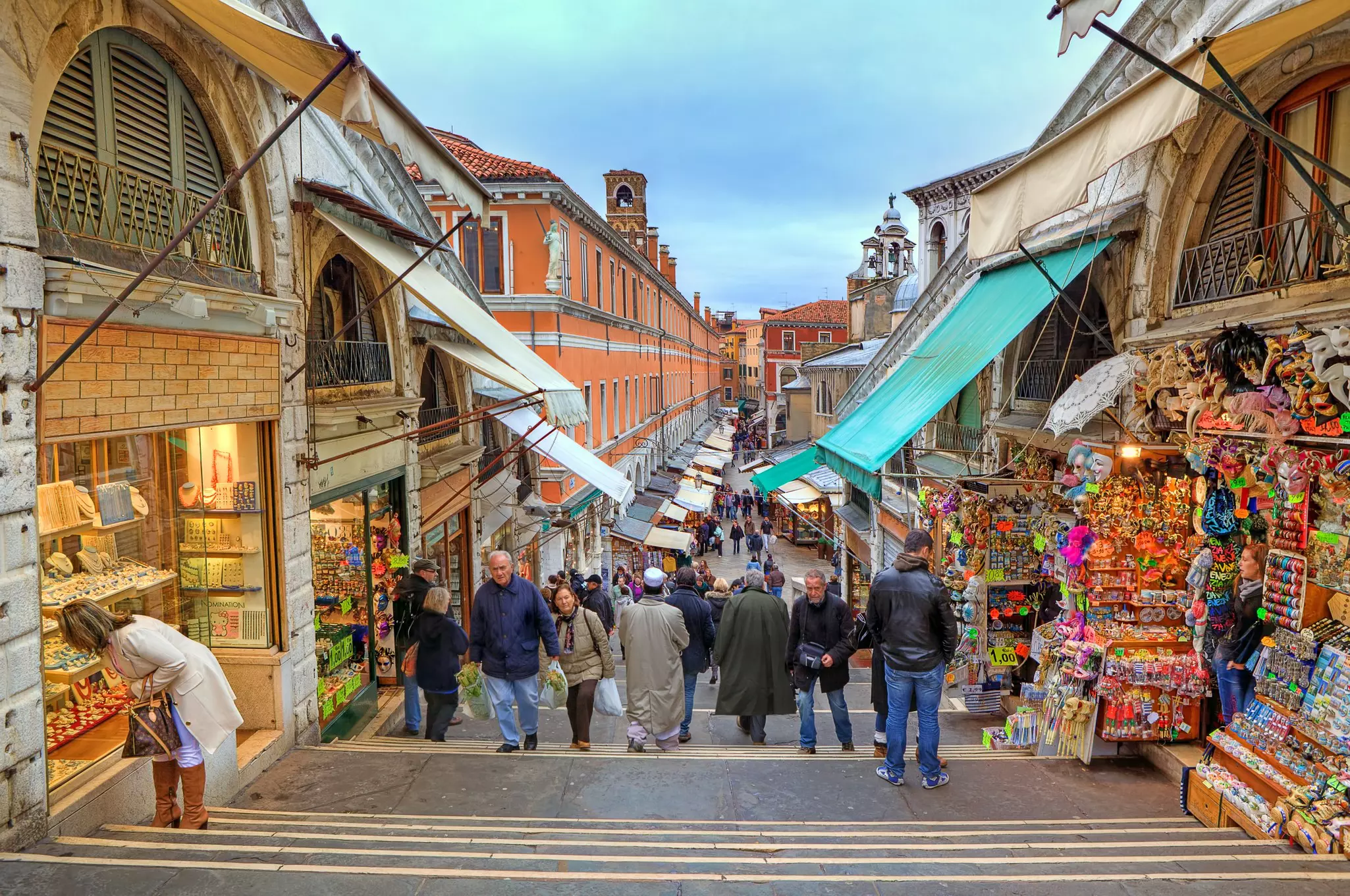 People walking an aisle between outdoor souvenir shops and stalls