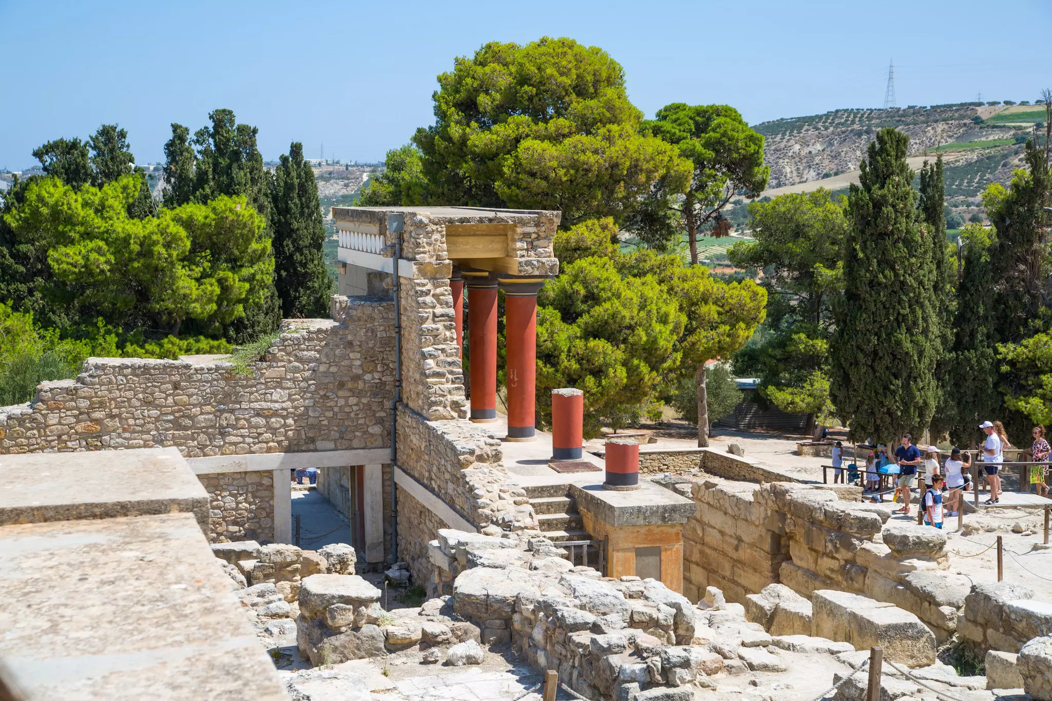 People admire the ruins of a temple in an archaeological site