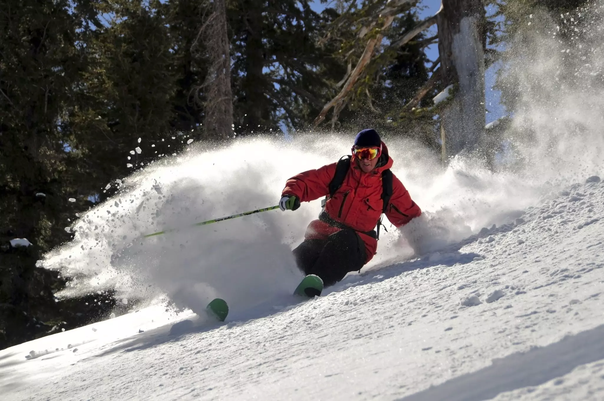 A person skiing downhill in a red jacket.