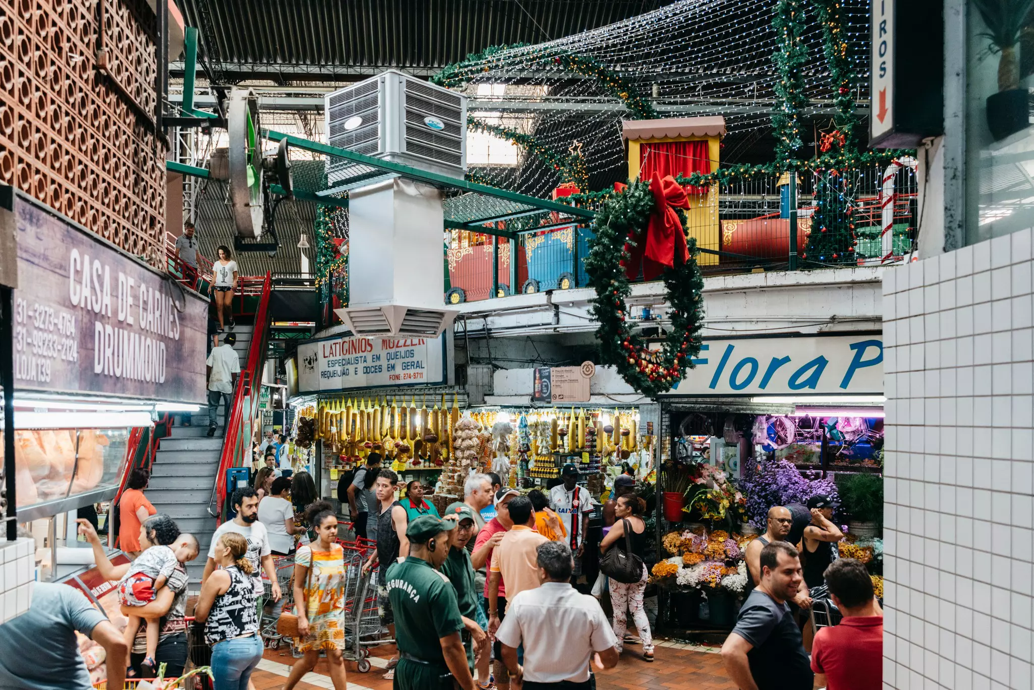 People strolling in a lively indoor market featuring food, crafts and souvenir vendors, and places to eat