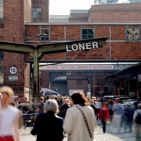 Crowds of people walk through an outdoor market
