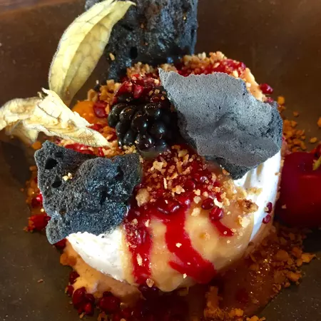A dessert topped with red sauce and berries