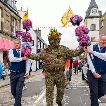 The decorated Burryman being led down the street in South Queensberry. Euan Cherry/Shutterstock