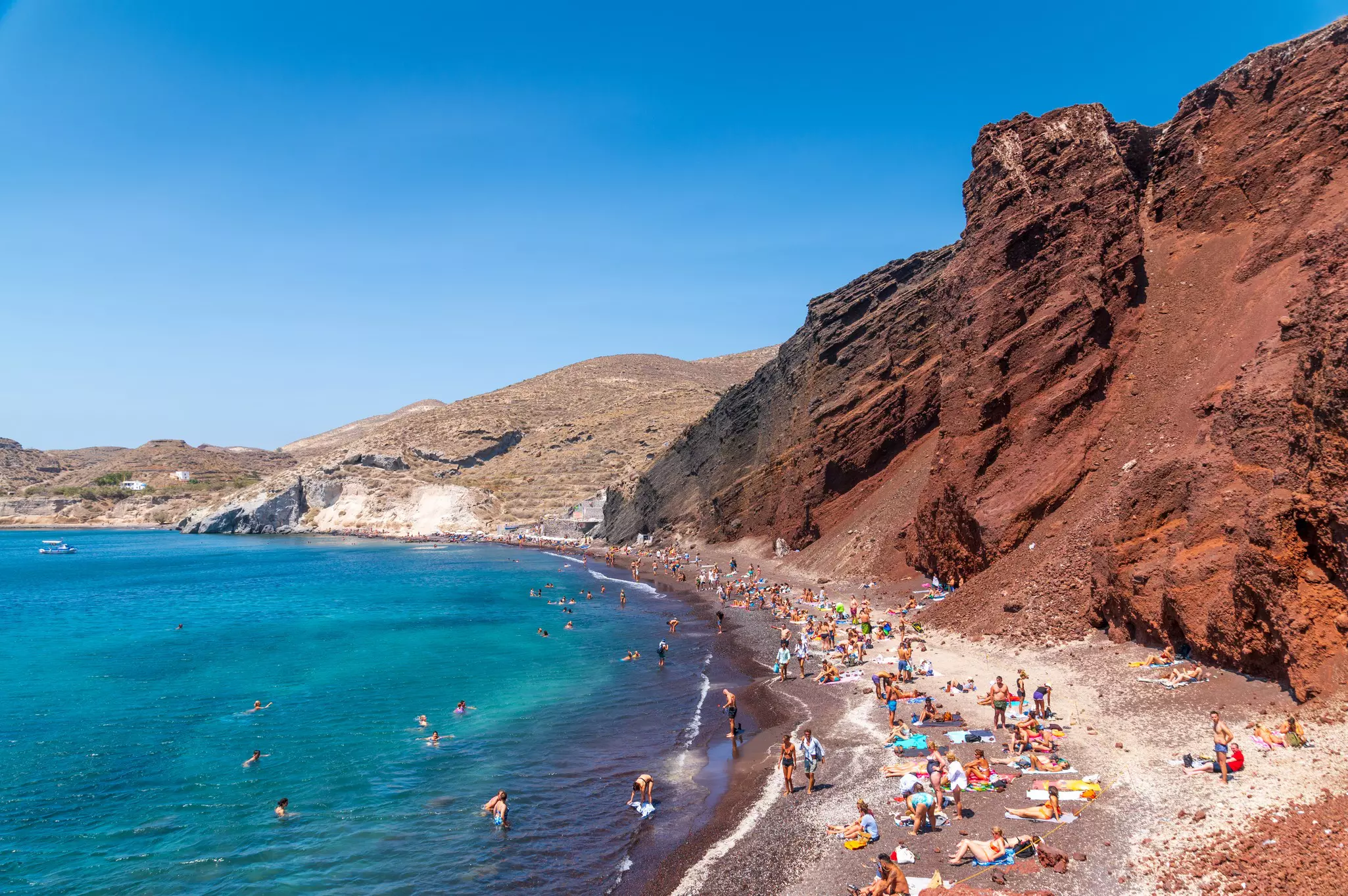 Sunbeds lined up against the red cliffs of the famous Red Beach.