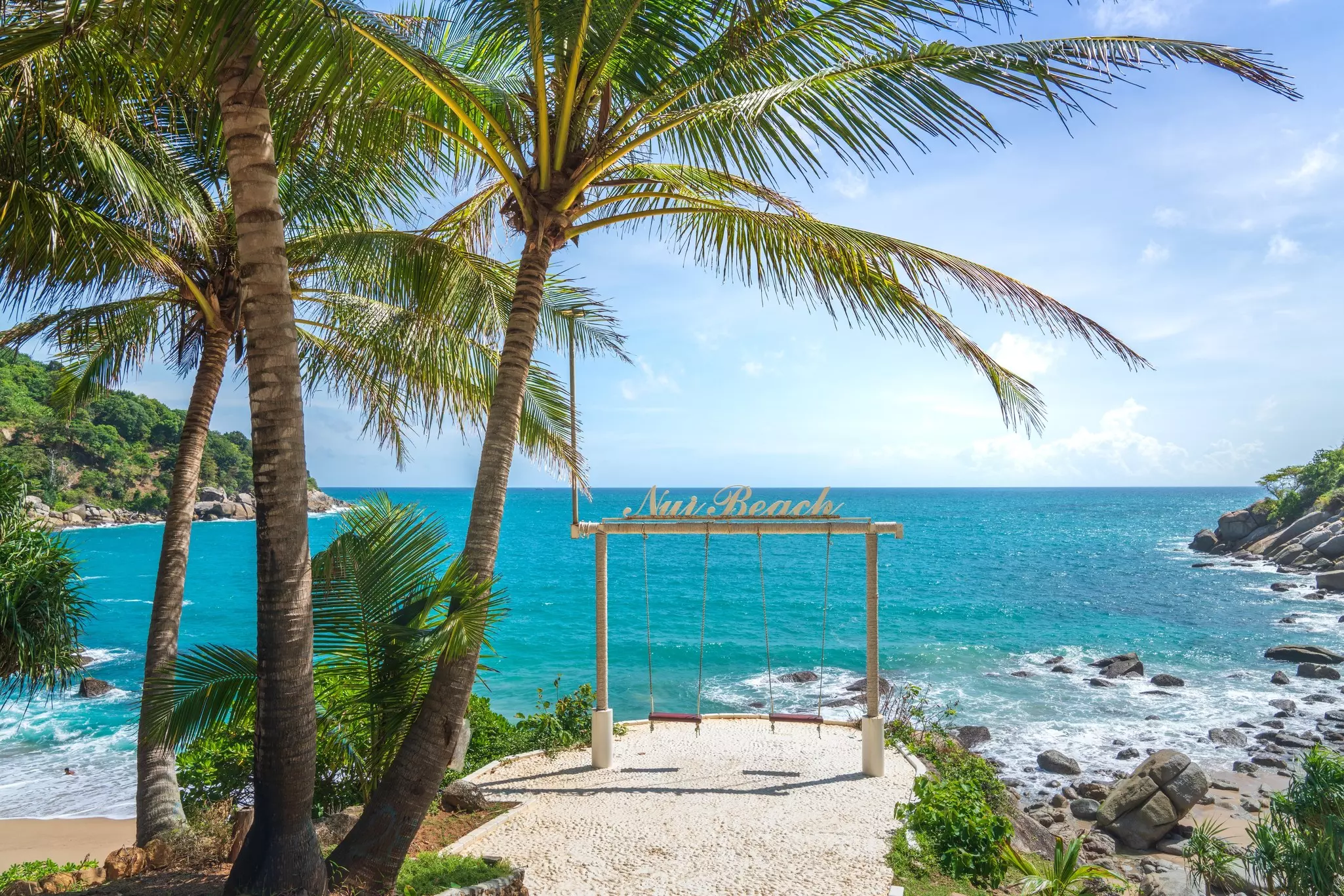 A swing set at the edge of a beach.