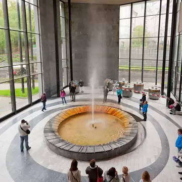 Visitors surround the geyser in the Hot Spring Colonnade. Karlovy Vary, Czech Republic.