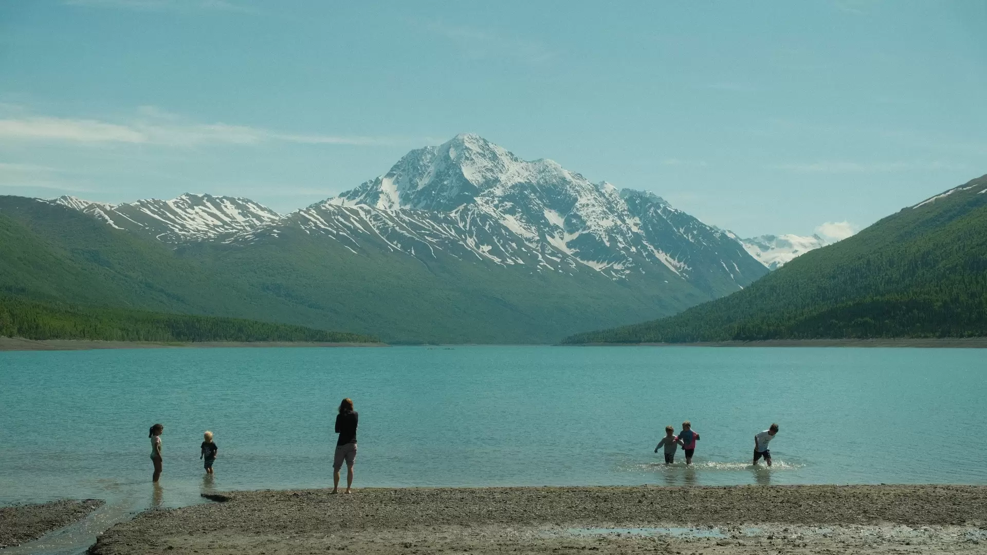 Anchorage, Alaska, United States - June 7th, 2024: Kid playing in water at Eklutna Lake, Anchorage Alaska in the summer