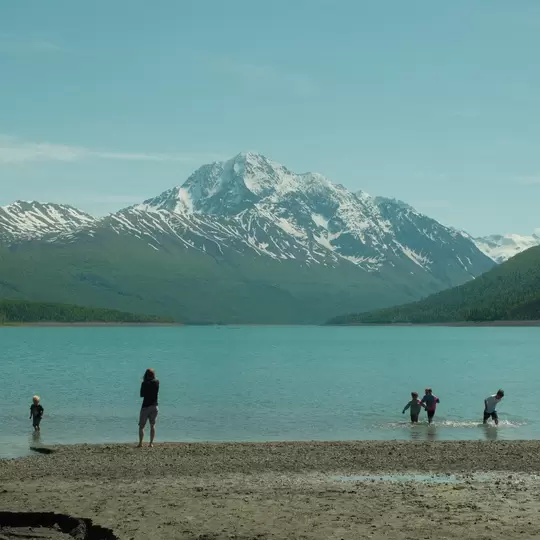 Anchorage, Alaska, United States - June 7th, 2024: Kid playing in water at Eklutna Lake, Anchorage Alaska in the summer