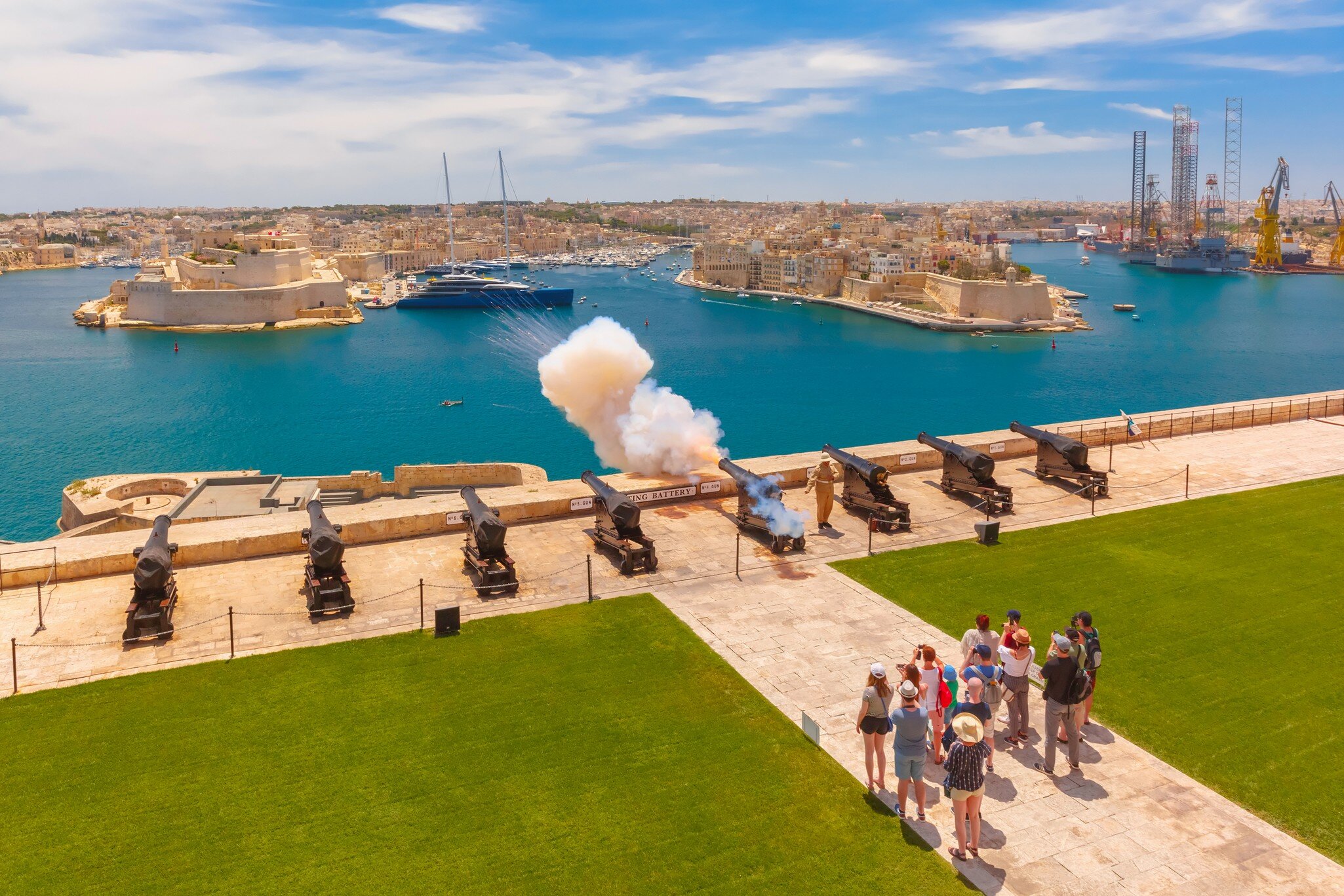 Valletta, Malta - January 9, 2020: Shot from cannon at noon in Saluting Battery at Upper Barrakka Gardens, with Birgu on the background, Valletta, Malta.