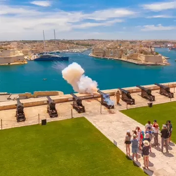 Valletta, Malta - January 9, 2020: Shot from cannon at noon in Saluting Battery at Upper Barrakka Gardens, with Birgu on the background, Valletta, Malta.