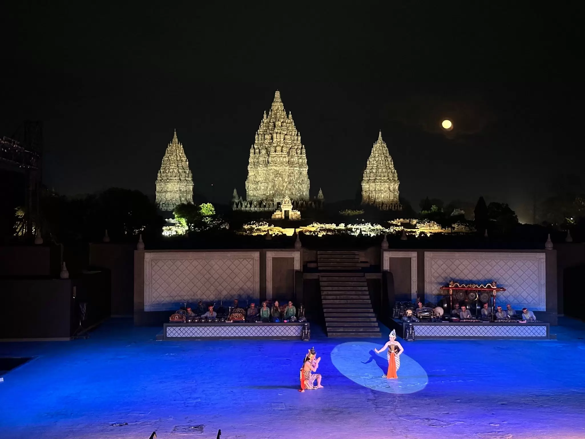 Spotlit dancers perform at night in front of three illuminated temple towers, Prambanan Temple Complex, near Yokagarta, Java, Indonesia