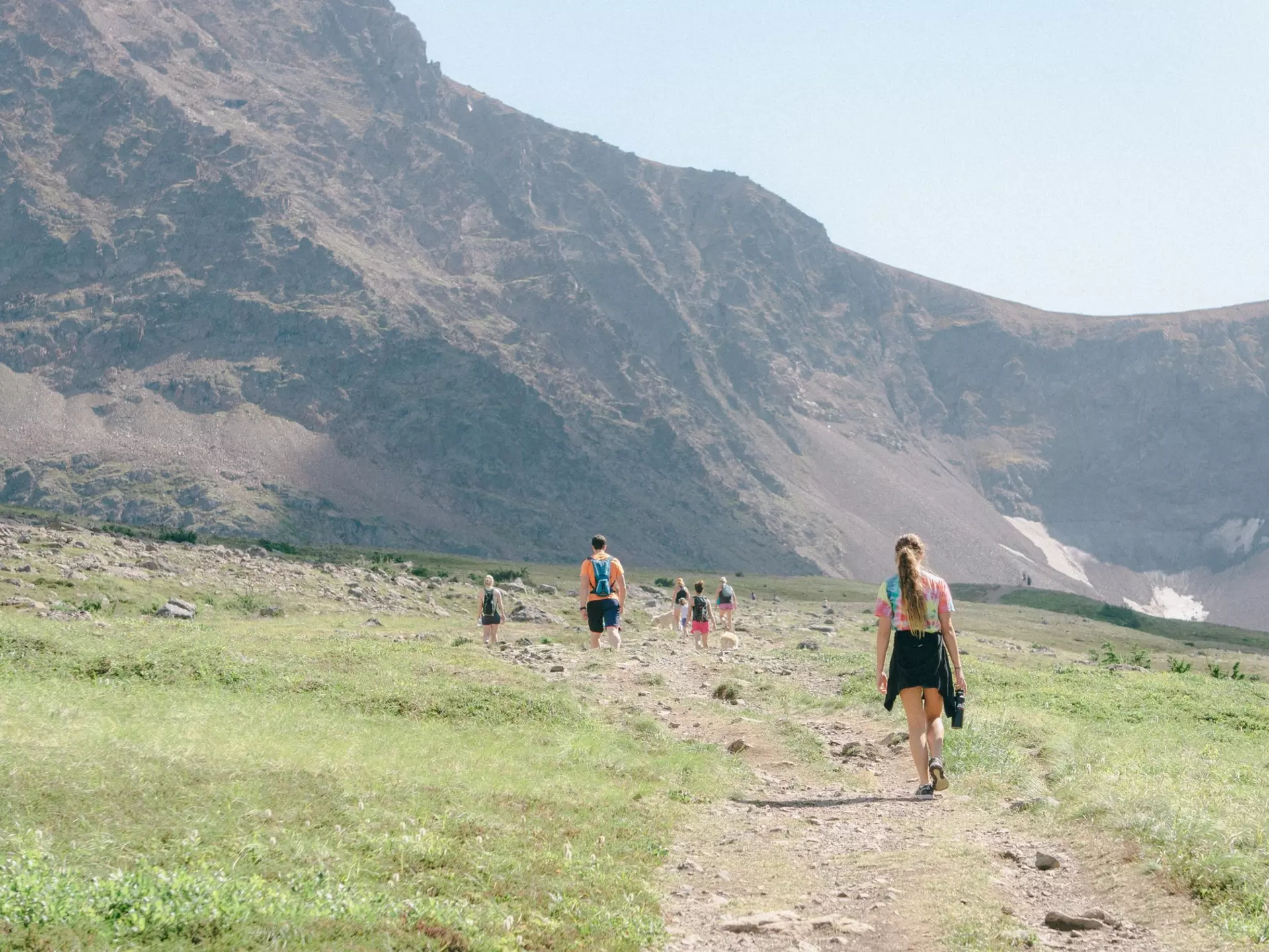 A family hiking along a trail towards a mountain in Alaska. 