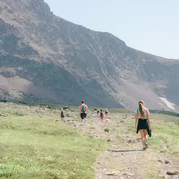 A family hiking along a trail towards a mountain in Alaska. 